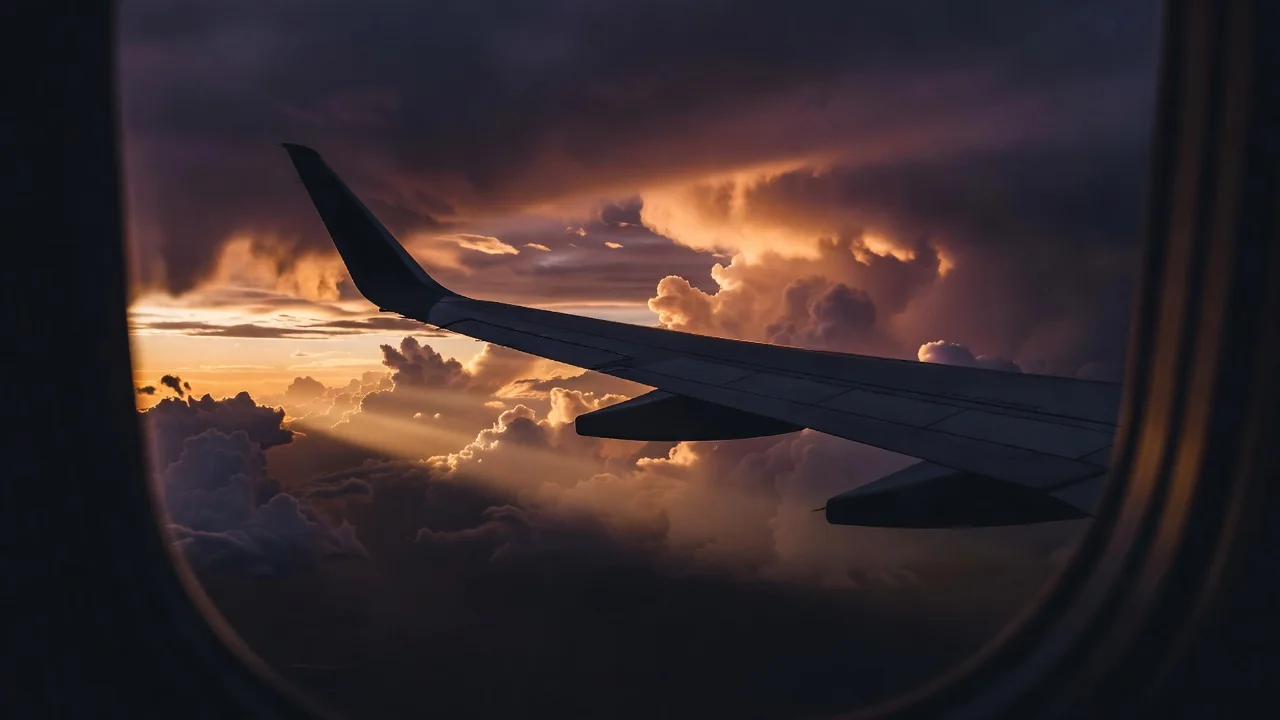 View through an airplane window at sunset clouds